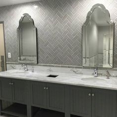 a bathroom with two sinks and mirrors in it