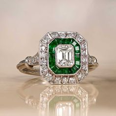 This item has just been reserved by another customer. Please contact us to be notified if it becomes available.  This beautiful platinum GIA-certified ring centers a 0.50-carat emerald-cut diamond with J color and VS1 clarity. A double halo of calibre-cut emeralds and diamonds surrounds the center stone. Additional diamonds are set along the shoulders. This ring is a handcrafted platinum design. ✦DIAMOND SPECIFICATIONS: Diamond Weight: 0.50 Carats Diamond Color: J Color Diamond Clarity: VS1 Clar Art Deco Engagement Ring Emerald, Diamond Ring With Halo, Ring With Halo, Estate Diamond Jewelry, Emerald Cut Diamond Ring, Emerald Engagement Ring Cut, Emerald Cut Diamond, Double Halo, Exclusive Jewelry