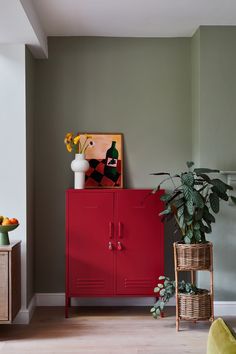 a red cabinet sitting in the corner of a living room