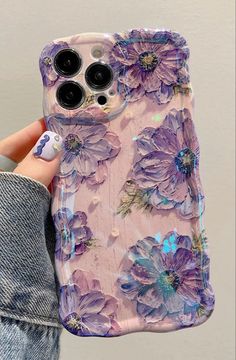 a person holding an iphone case with purple flowers on it