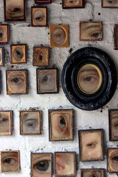 many framed pictures are hanging on the wall with an eyeball in front of them