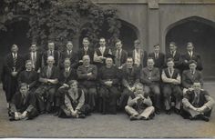 an old black and white photograph of men in suits posing for a group photo together