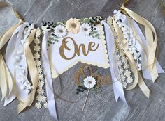 a one sign with flowers and ribbons around it on a table next to some scissors