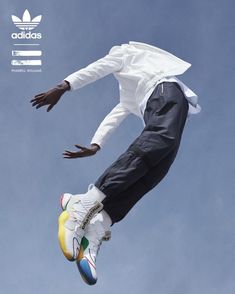 a man in white shirt and black pants doing a trick on a skateboard