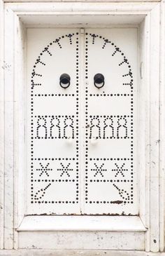 a white door with two black knobs on it's sides and numbers painted on the doors