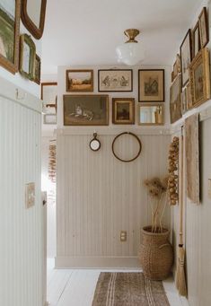 a hallway with pictures on the wall and a rug