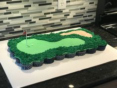 a cake shaped like a golf course on top of a counter