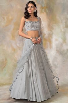 Grey Hand Embroidered Lehenga Set Featuring a grey lehenga in georgette base with sequins, cutdana, aari, beads and crystal hand embroidery. It is paired with a matching cutwork blouse and a net dupatta. This product will be shipped to you after 1-2 weeks from the date of order placed. All custom made orders are not returnable. Pls contact for Size chart and for other more colors Request You :To provide contact details for courier services. {VARIATION MAY COME DEPENDING UPON AVALIBILITY OF LACES OR GOTTA PATI} NOTE:  1) Visual Samples on website may differ slightly from actual product due to light & effects during photography (Length & Breadth have 1 n 1.5 inches +/-). 2) Before placing order ,pls confirm product n color availability on +91 7903893945 & +91 8447750028(WhatsApp) 3) For Whol Grey Lehenga, Cutwork Blouse, Lehenga Designs Simple, Independance Day, Lehenga Blouse Designs, Net Lehenga, Embroidered Lehenga, Lehenga Blouse, Embellished Blouse