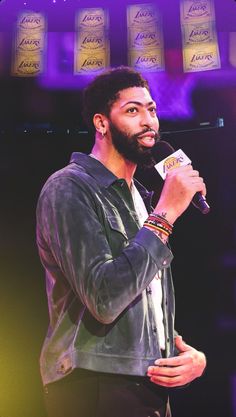 a man standing in front of a microphone holding a piece of paper with writing on it