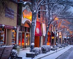 a snowy street lined with shops and benches