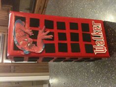 a red and black box with a spiderman sticker on the front sitting on a kitchen counter