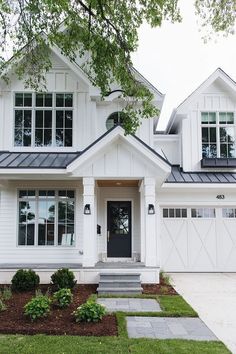 a large white house with lots of windows on the front and side of it's roof