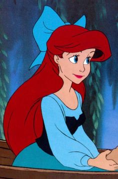 ariel from the little mermaid with red hair and blue eyes, looking to her left