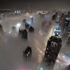 the city is surrounded by fog and skyscrapers