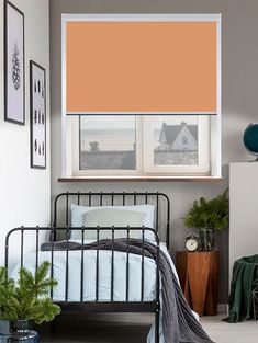 a bedroom with orange shades on the windows