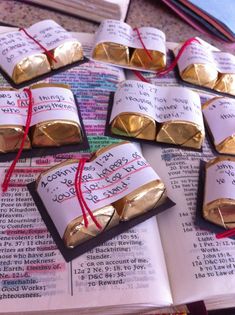 several pieces of gold foil wrapped in red string on top of an open bible book