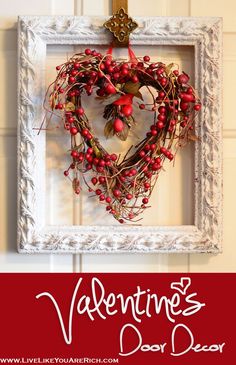 a heart shaped wreath hanging on the wall next to a white frame with a cross