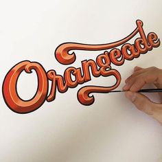 someone is drawing the word orangeade on a piece of paper