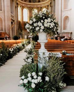 flowers and greenery are arranged on the floor in front of pews