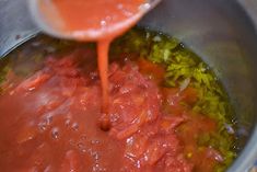 the sauce is being poured into the pot