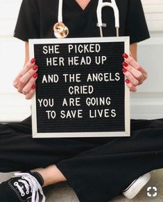 a woman holding a sign that says she picked her head up and the angels you are going to save lives