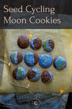 the moon cookies are made with chocolate and blue icing, on top of a cookie sheet