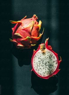 a dragon fruit cut in half on a black surface by jovo studio for stocks & bonds