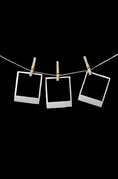 three polaroid frames hanging on a clothes line with clothes pins attached to them against a black background