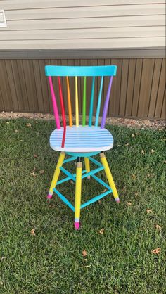 a colorful wooden chair sitting in the grass