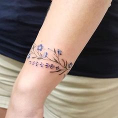 a woman's arm with flowers on it and the word love written in cursive writing