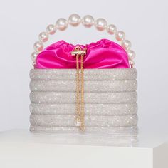 Experience the understated elegance of the Raen Crystal & Pearl Handle Evening Clutch Bag. A sleek clutch bag crafted from fine fabric in a choice of six colors, each bag is adorned with a sparkling crystal, pearl handle and beautiful satin pouch with golden draw string. Its graceful, timeless style adds a touch of sophistication to your evening ensemble. SIZE: L19.5 x W10 x H12cm Gender: WOMENShape: Barrel-shapedPattern Type: PatchworkMain Material: MetallicLining Material: SATINExterior: Solid Satin Pouch, Pearl Clutch, Bag Decoration, Pearl Decorations, Diamond Decorations, Pink Clutch, Crystal Bags, Crystal Clutch, Metallic Bag