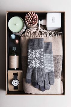 an open box containing gloves, candles and other items