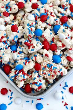 red, white and blue popcorn with sprinkles in a square dish on a table