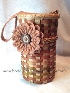 a woven basket with a flower on the side and a metal button in the center