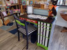 a desk and chair in a room with many items on the table, including a sign that says it's showtime