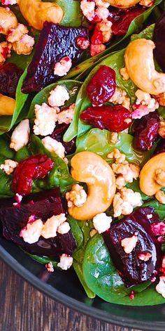 a salad with beets, walnuts and cranberries in a black bowl