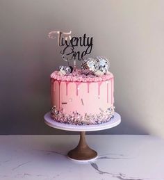 there is a pink cake with white frosting on the top that says twenty and one