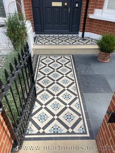 a black and white tiled entrance way with potted plants on the steps next to it