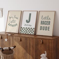 three framed pictures on top of a wooden cabinet next to a basket and stuffed animal