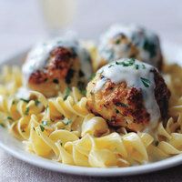 some meatballs and pasta on a white plate