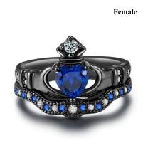 a ring with a heart shaped blue stone surrounded by diamonds