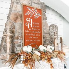 a fireplace mantel decorated with pumpkins and greenery in front of a sign that says autumn blows upon us like a splendid evening it is the very sunset