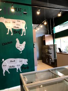 a restaurant with green walls and signs on the wall that read, meat menus