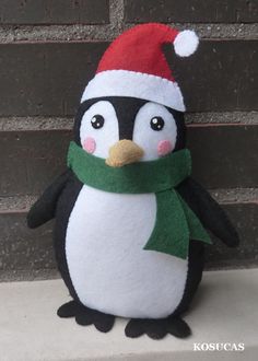 a stuffed penguin wearing a santa hat and scarf