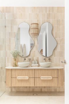 A bathroom features a double vanity with brushed nickel tapware, abstract mirrors and travertine tiles as a feature on the wall behind. Tile Laying Patterns, Bali Villa, Renovation Design, Shower Taps