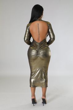 the back view of a woman in a gold dress with her hands on her hips