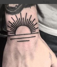 a hand with a sun tattoo on it