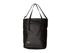 a black tote bag is shown on a white background, with the handles down