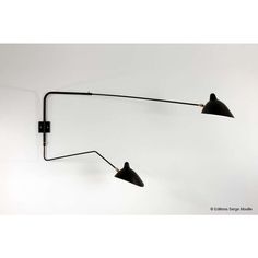 two black lamps on a white wall with one light turned on and the other turned off