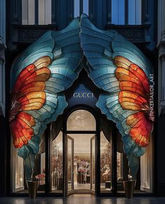 the entrance to a luxury store with large butterfly wings